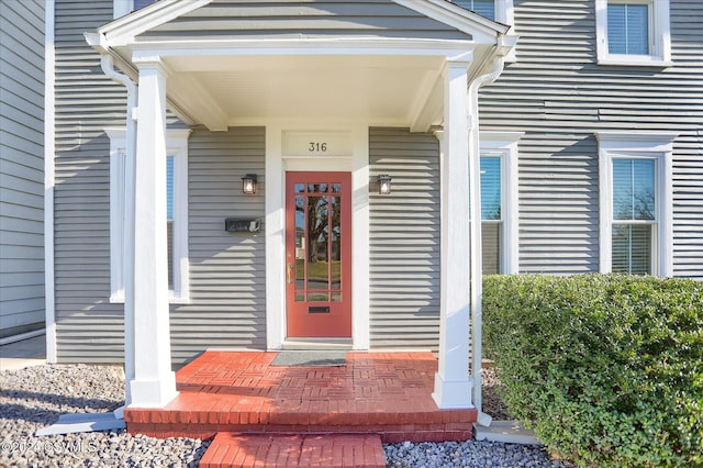 view of exterior entry featuring covered porch