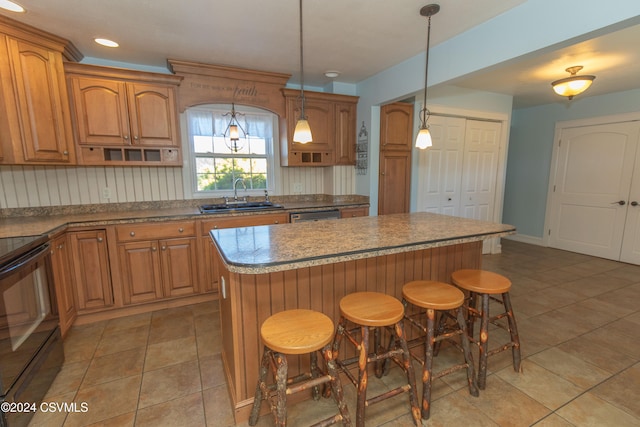 kitchen with hanging light fixtures, a breakfast bar area, a center island, and sink