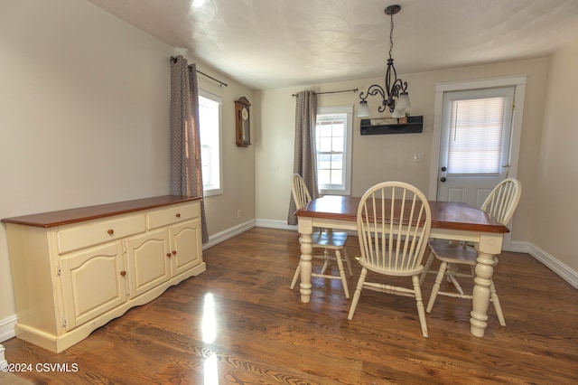 dining room with dark hardwood / wood-style flooring and a notable chandelier