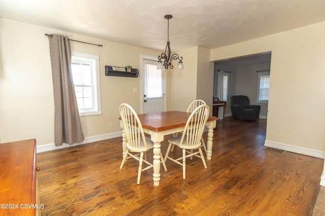 dining area featuring dark hardwood / wood-style flooring and a notable chandelier