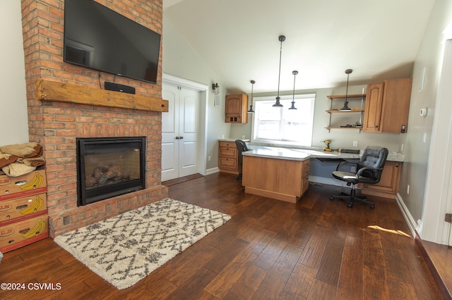 kitchen featuring built in desk, dark hardwood / wood-style floors, decorative light fixtures, a kitchen island, and vaulted ceiling