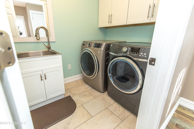 laundry room with cabinets, light tile patterned flooring, sink, and independent washer and dryer