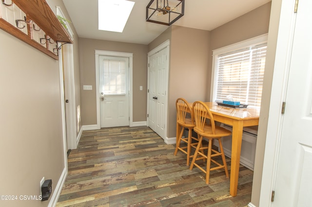 dining space featuring dark hardwood / wood-style flooring and a skylight