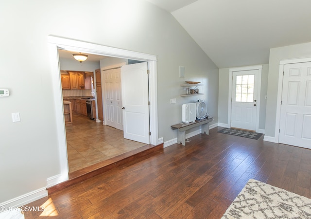 foyer with dark hardwood / wood-style floors and lofted ceiling