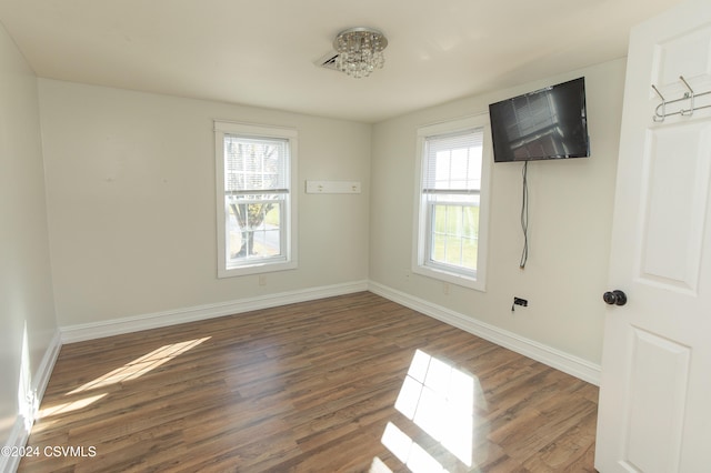 empty room with dark wood-type flooring and a healthy amount of sunlight