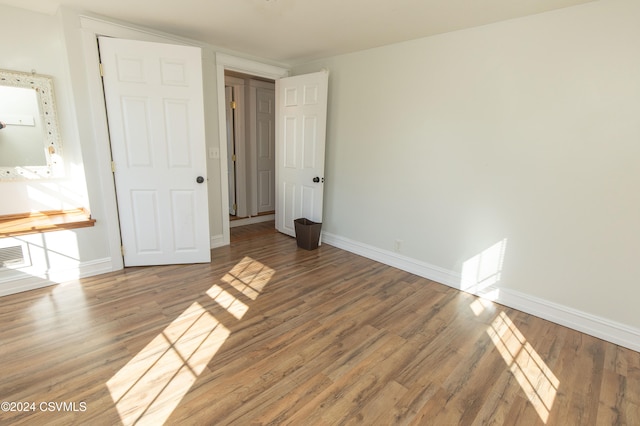 unfurnished bedroom with a closet and hardwood / wood-style flooring