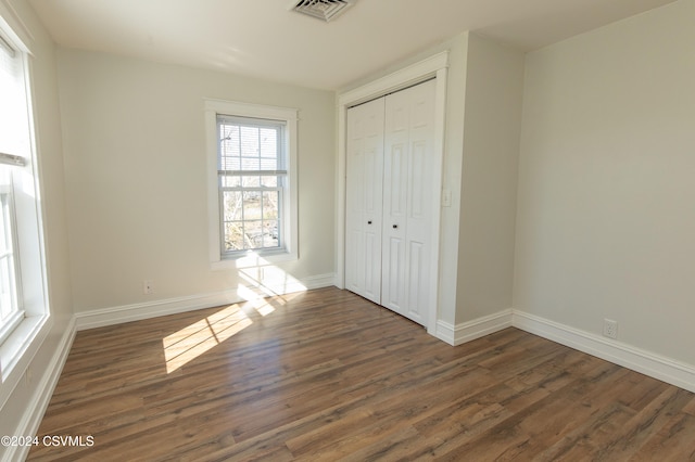 unfurnished bedroom featuring dark wood-type flooring and a closet