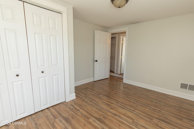 unfurnished bedroom featuring hardwood / wood-style floors and a closet