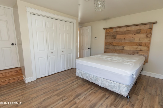 bedroom with dark hardwood / wood-style flooring and a closet