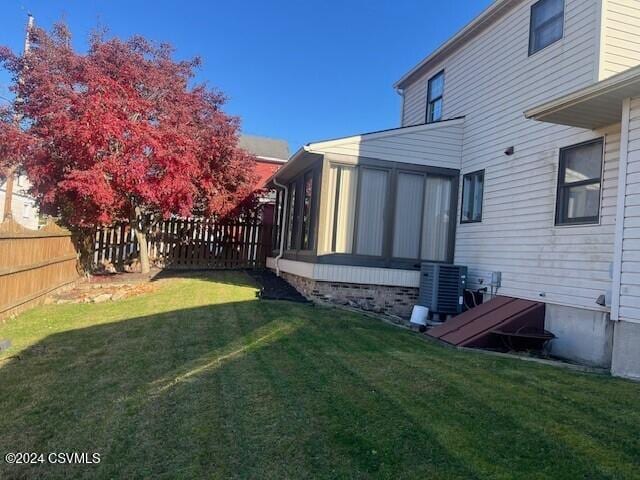 view of yard with a sunroom and cooling unit