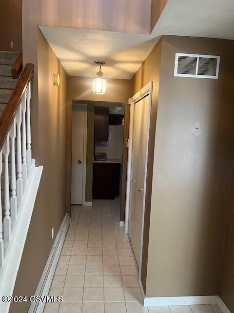 corridor featuring baseboard heating and light tile patterned floors