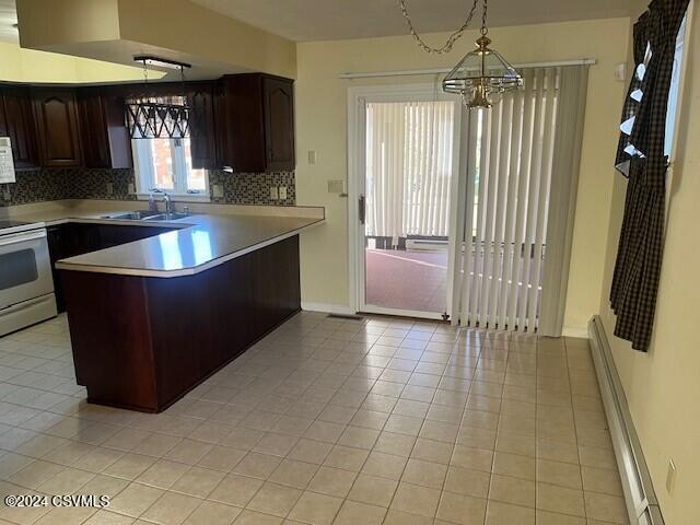 kitchen featuring decorative backsplash, dark brown cabinetry, white appliances, and decorative light fixtures