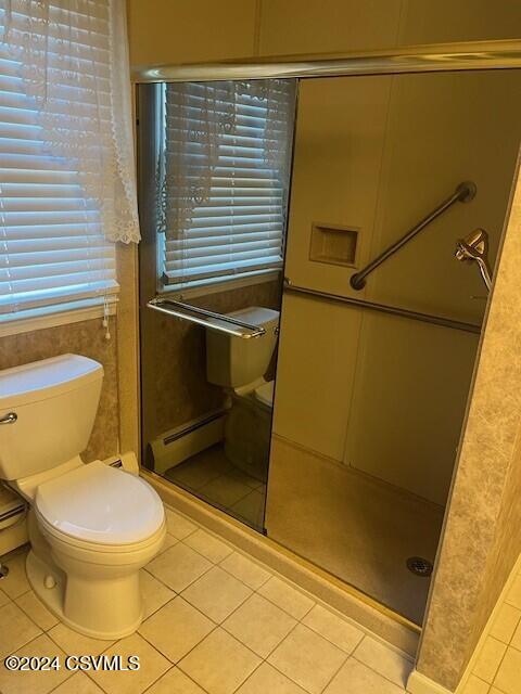 bathroom featuring toilet, an enclosed shower, and tile patterned flooring