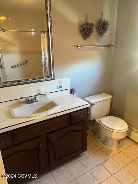 bathroom featuring vanity, walk in shower, tile patterned floors, and toilet