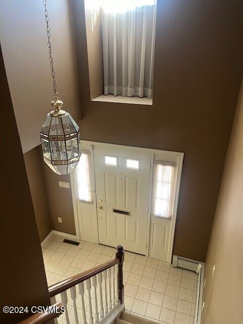 tiled foyer entrance featuring a notable chandelier