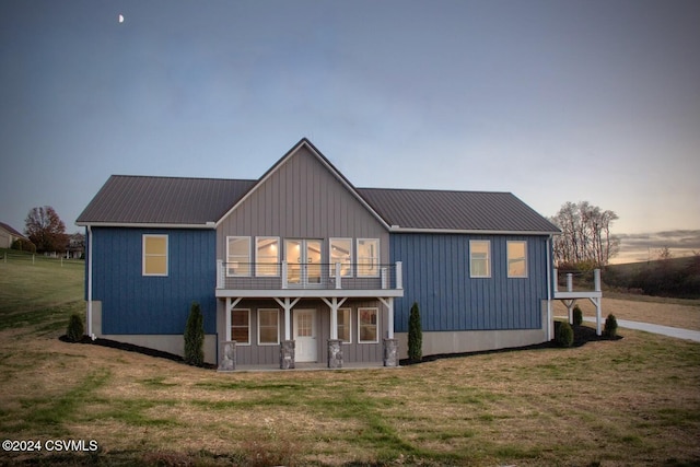 modern inspired farmhouse featuring a lawn and a balcony