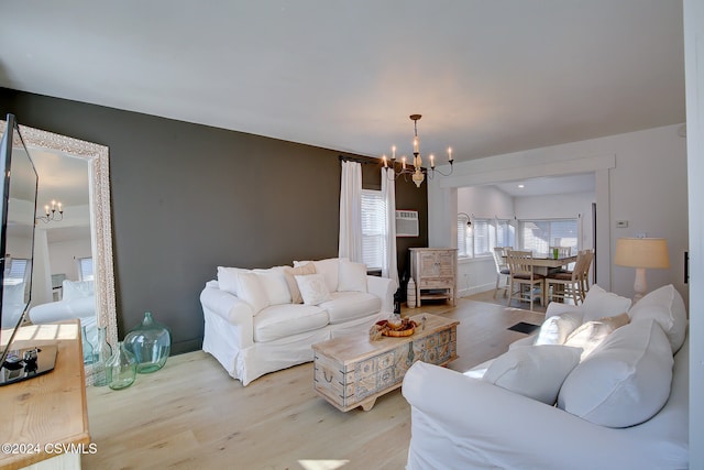 living room featuring light wood-type flooring and an inviting chandelier