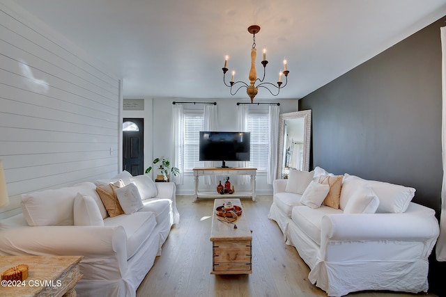 living room featuring light wood-type flooring and an inviting chandelier