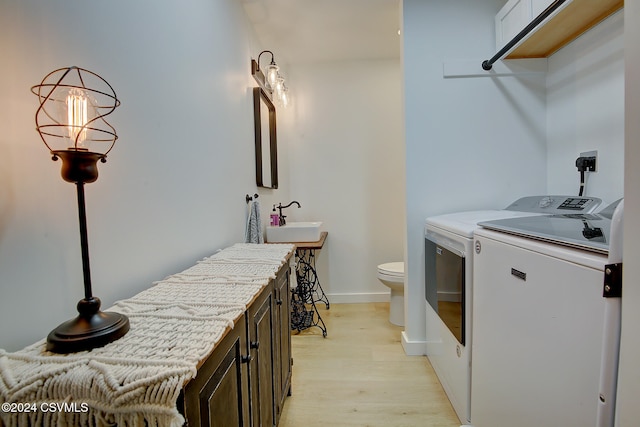 interior space featuring washing machine and dryer, sink, and light hardwood / wood-style floors