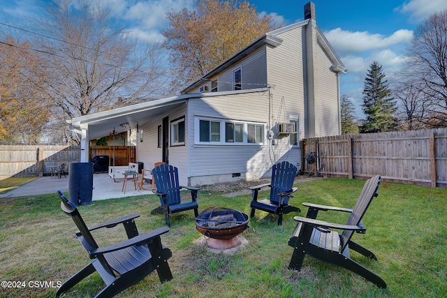 back of house featuring a patio, a yard, and an outdoor fire pit