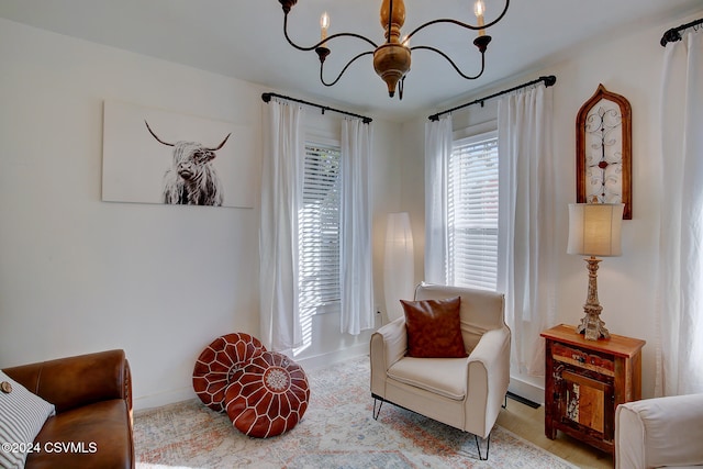 sitting room with a notable chandelier and light carpet