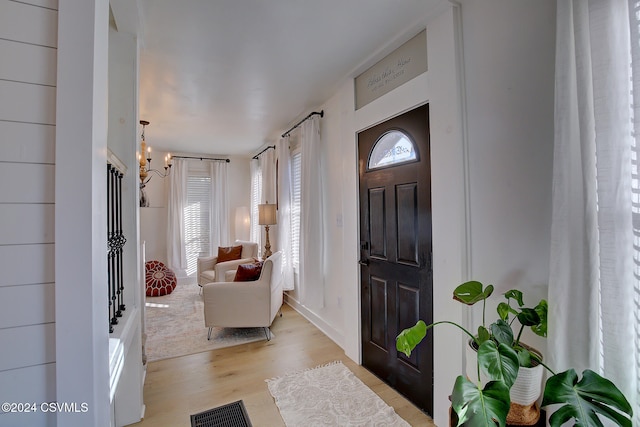 foyer entrance with an inviting chandelier and light wood-type flooring