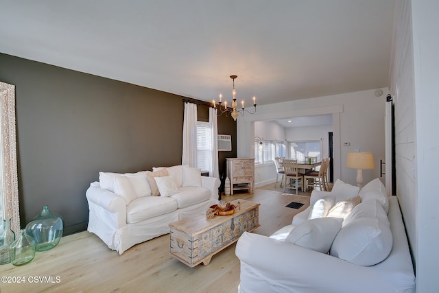 living room with light wood-type flooring and a notable chandelier