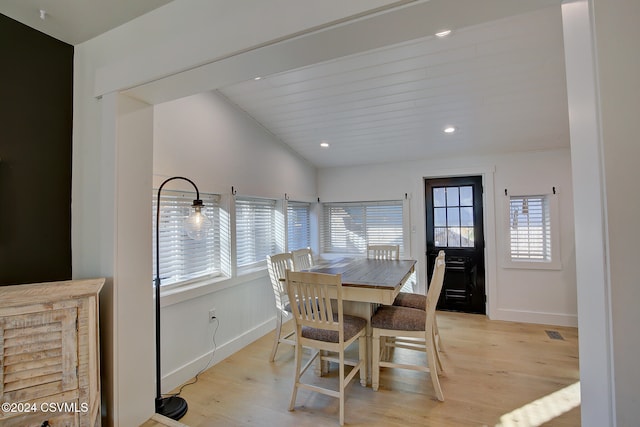 dining area with light hardwood / wood-style floors and lofted ceiling