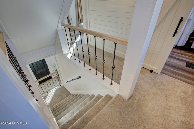 stairs with carpet flooring and a towering ceiling