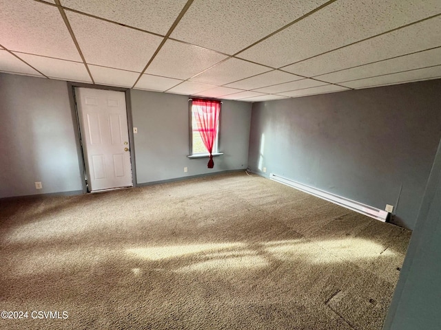 empty room featuring carpet flooring, a paneled ceiling, and baseboard heating