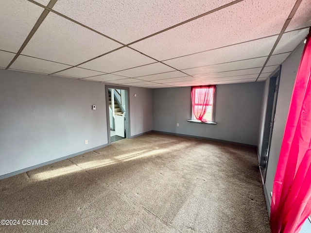 spare room featuring carpet flooring and a paneled ceiling