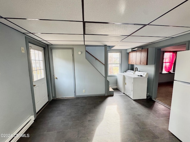 washroom with cabinets, separate washer and dryer, and a baseboard heating unit