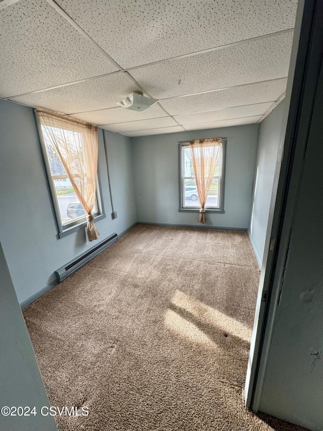 spare room featuring carpet flooring and a baseboard heating unit