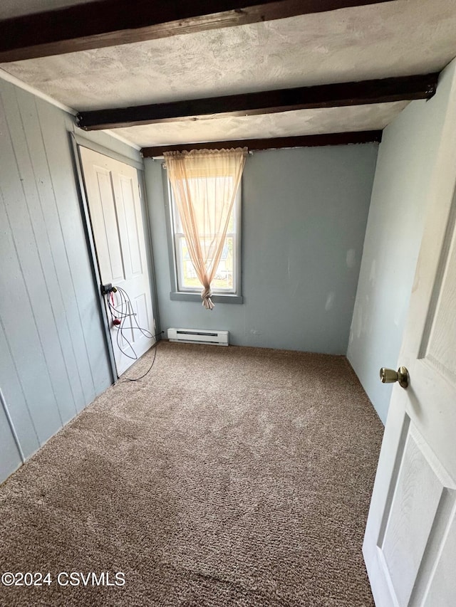 spare room with beamed ceiling, carpet floors, and a baseboard heating unit