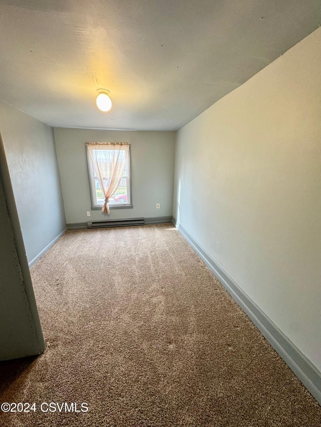 unfurnished room featuring carpet floors and a baseboard heating unit