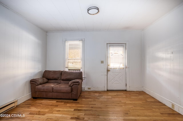 interior space featuring light hardwood / wood-style floors, baseboard heating, and crown molding