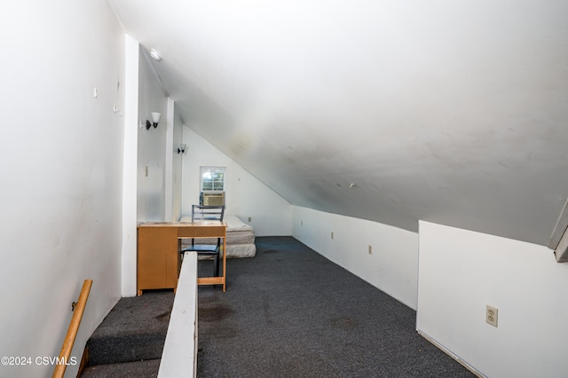 unfurnished office with vaulted ceiling and dark carpet