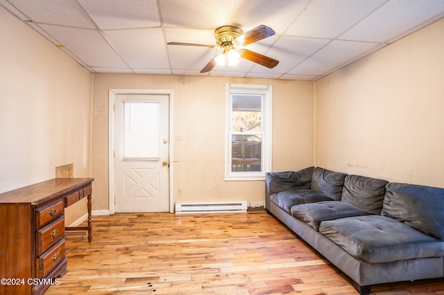 living room with a paneled ceiling, ceiling fan, light hardwood / wood-style floors, and a baseboard radiator