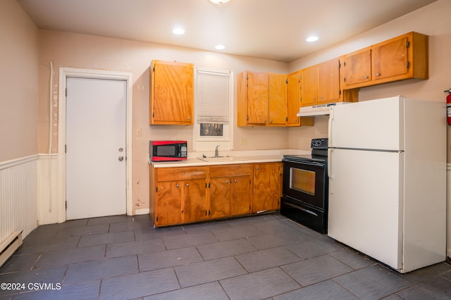 kitchen with baseboard heating, sink, and black appliances