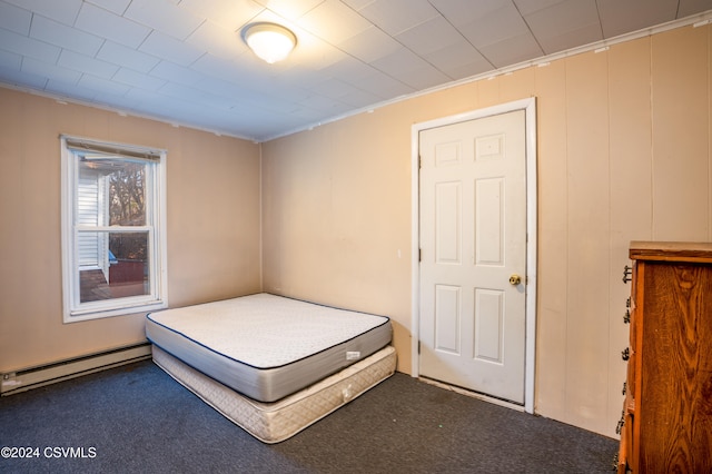 unfurnished bedroom featuring baseboard heating, carpet, and ornamental molding