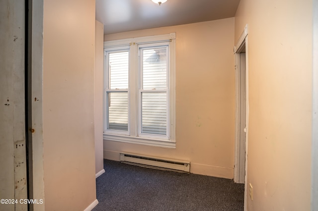 hallway featuring baseboard heating and dark colored carpet