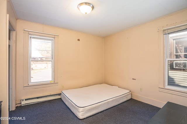 unfurnished bedroom with dark carpet, baseboard heating, and crown molding