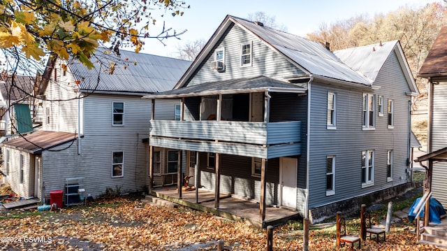 rear view of property featuring a balcony and cooling unit