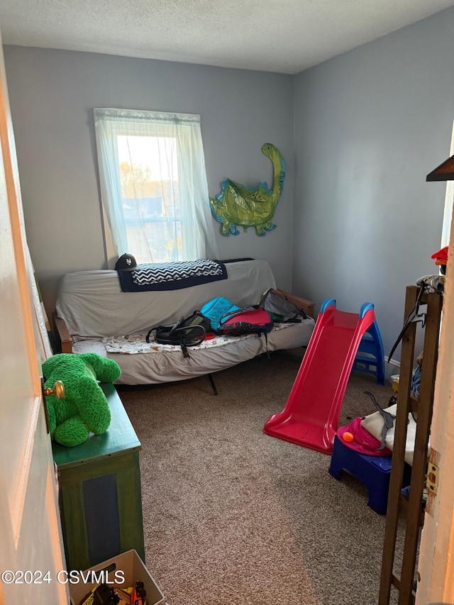 bedroom featuring carpet floors and a textured ceiling