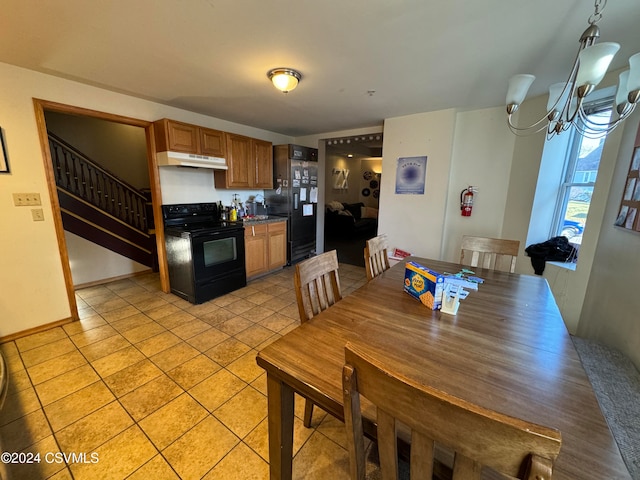 kitchen featuring a chandelier, light tile patterned floors, black appliances, and decorative light fixtures