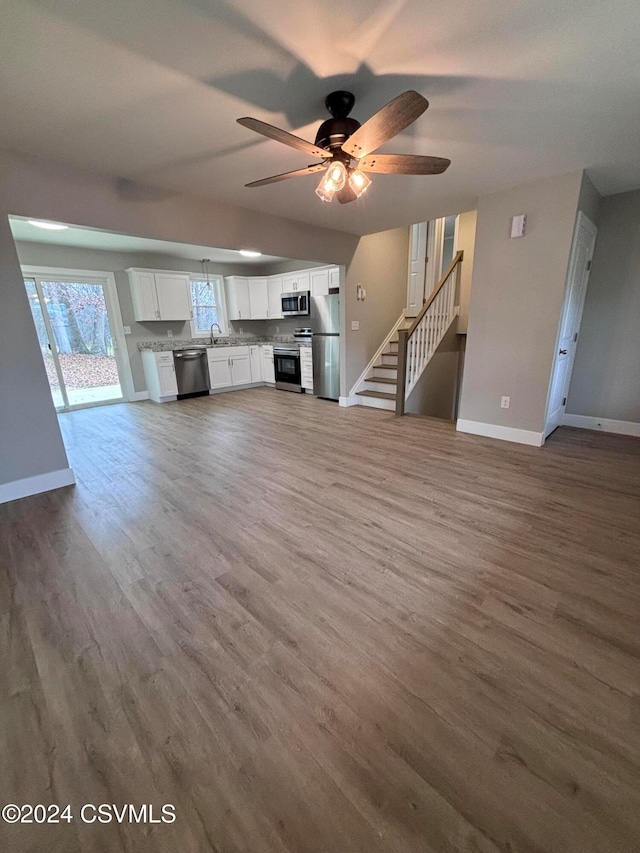 unfurnished living room with hardwood / wood-style floors and ceiling fan