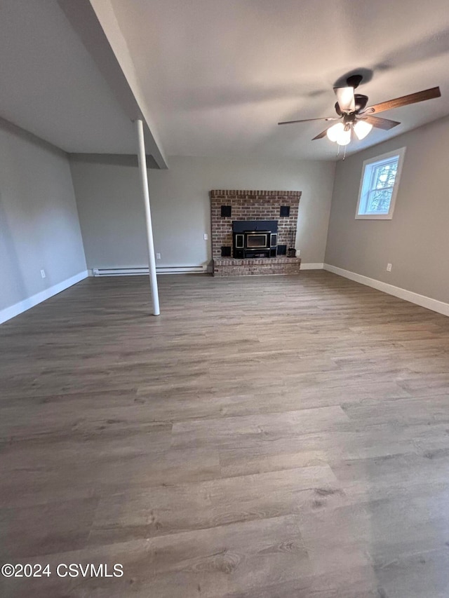 unfurnished living room featuring wood-type flooring, a brick fireplace, ceiling fan, and a baseboard heating unit