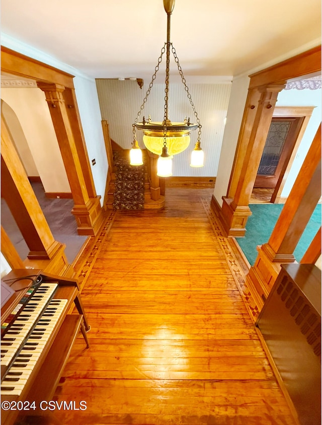 corridor featuring hardwood / wood-style floors and decorative columns