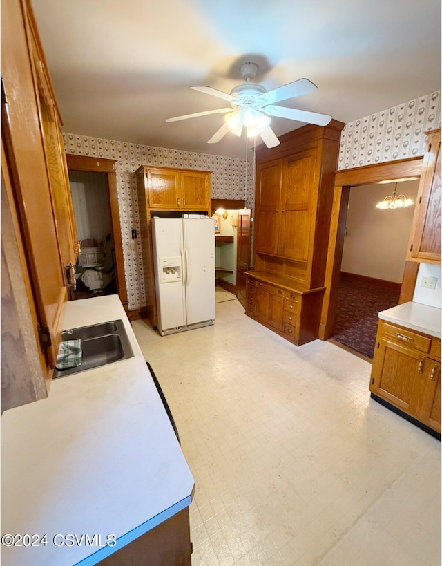 kitchen with ceiling fan, white fridge with ice dispenser, and sink