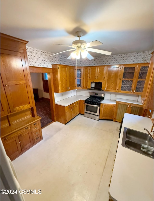 kitchen with ceiling fan, stainless steel gas range oven, and sink